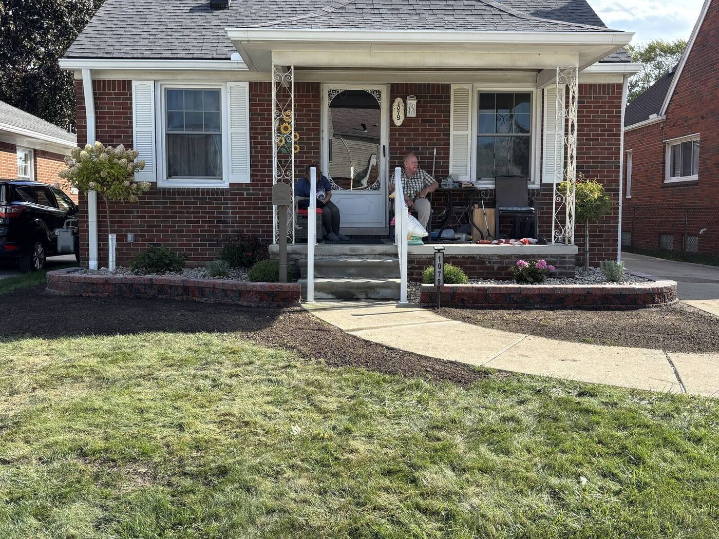 After: new red block garden wall beds, river rock and plantings